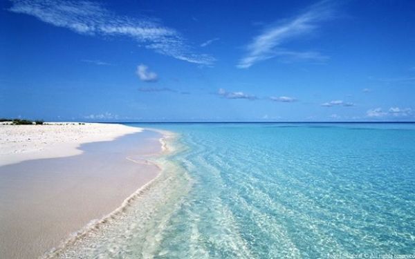 Praia com areia branca e um mar azul, simplesmente paradisíaca perto de Lisboa